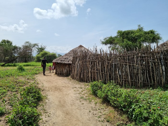 Three persons entering a homestead in Uganda