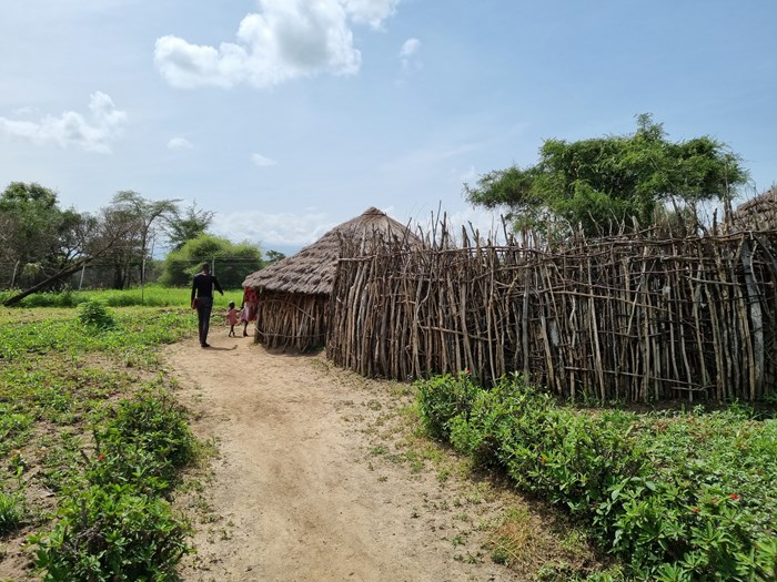 Three persons entering a homestead in Uganda