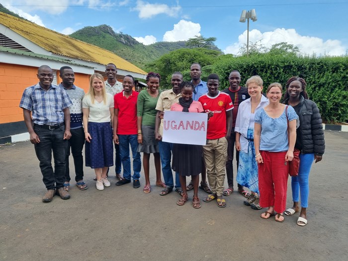 A group photo with a Uganda sign