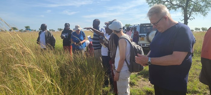 Woman explains something to a group in a grassland