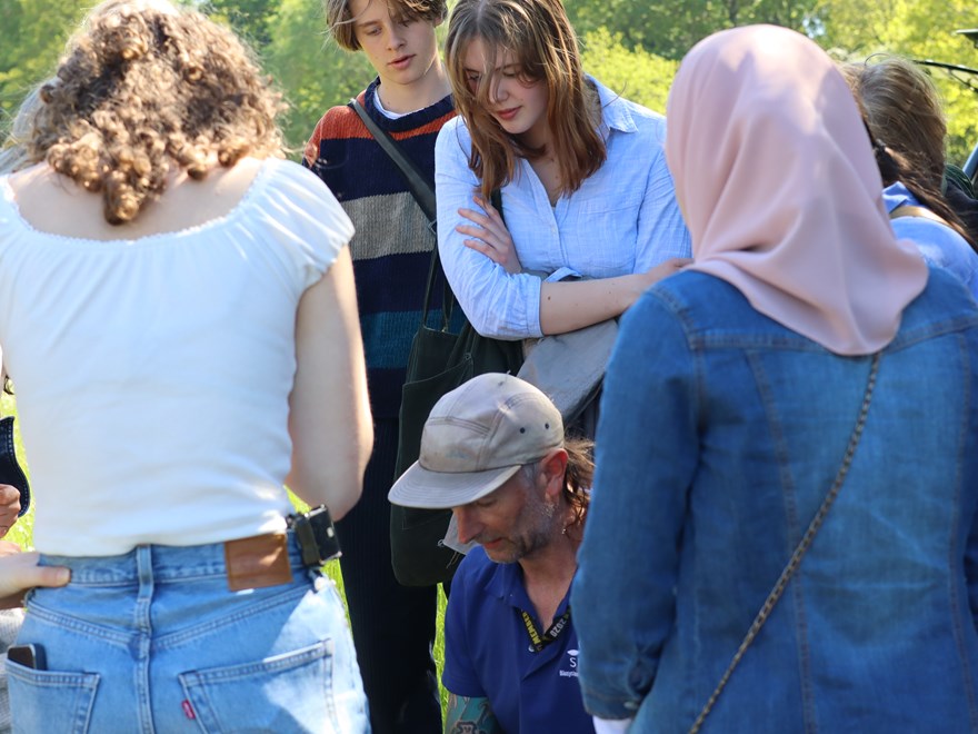 High school students looking at a drone