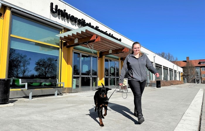 En hundägare kommer ut med sin hund från UDS.