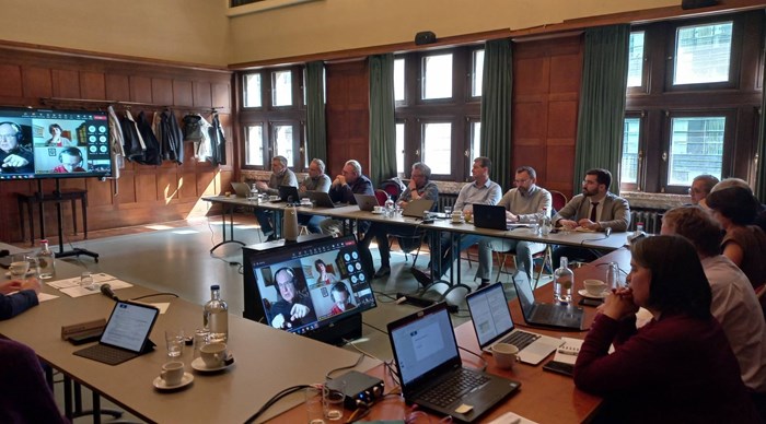 Ett stort antal personer sitter vid konferensbord. 