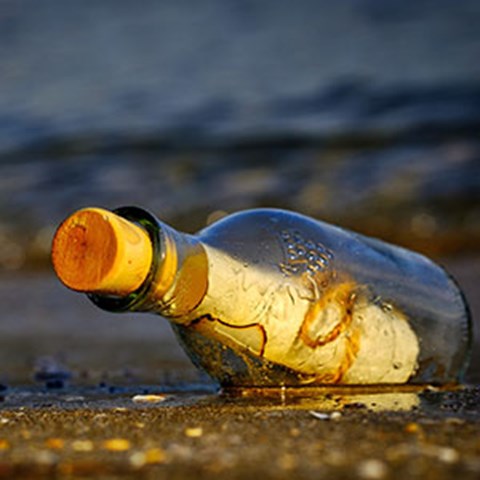 A glass bottle floating in the water. Photo.