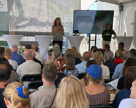 Ett seminarium hålls med publik på akterdäck på ett fartyg, två kninnor syns på scenen. Foto.
