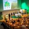 Sju personer står på en scen med en presentation i bakgrunden. Foto.