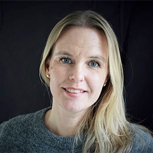 Portrait photo of a woman with long, blonde hair against a black background. Photo.