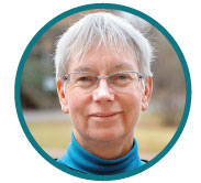 A woman with short gray hair and glasses. Portrait photo.