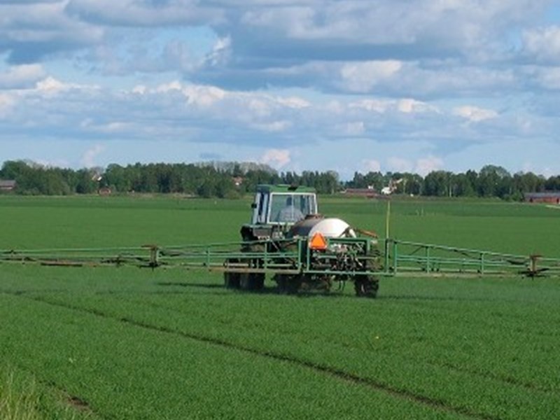 Tractor with agricultural sprayer for pesticides, photo.
