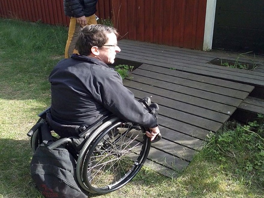 Person i rullstol framför en dåligt byggd ramp.