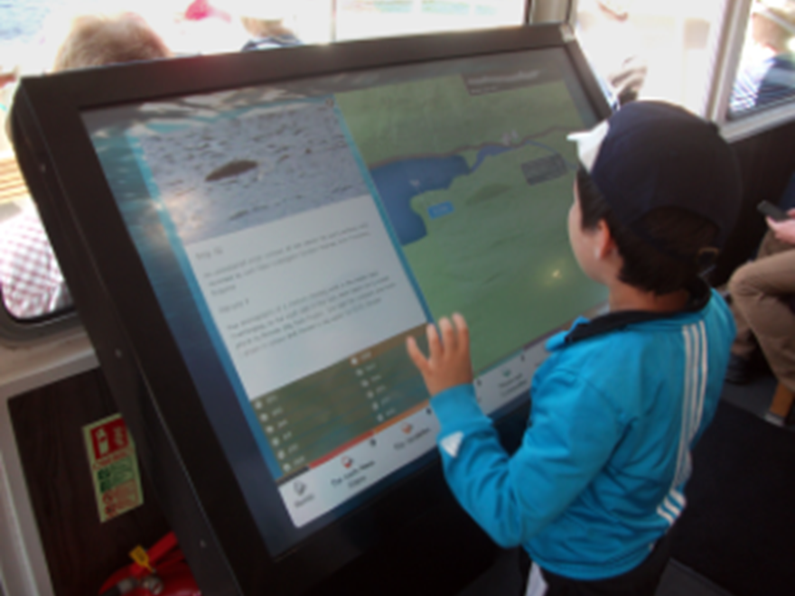Ung besökare vid interaktiv digital skylt, Loch Ness, Skottland. 