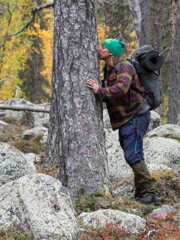 Naturvägledare Sebastian Kirppu pussar ett träd.