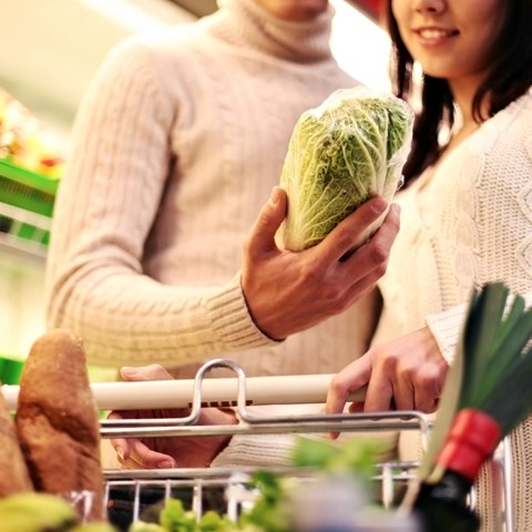 Consumers in store holding salad.
