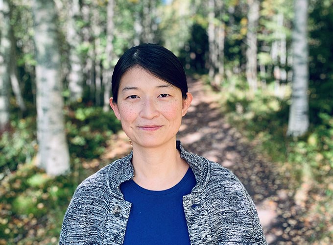 Kvinna i ljus och solig skog. Porträttfoto. 