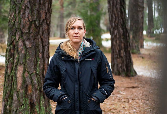 Forskaren Line Djupström står i en gammal tallskog.