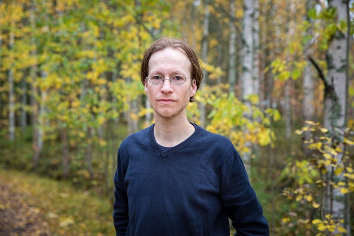 Forskaren Tim Horstkotte står i en skog med höstlöv.