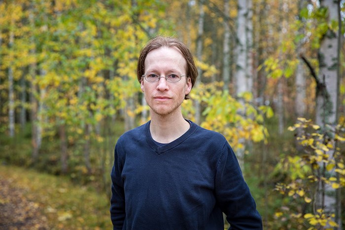 Forskaren Tim Horstkotte står i en skog med höstlöv.