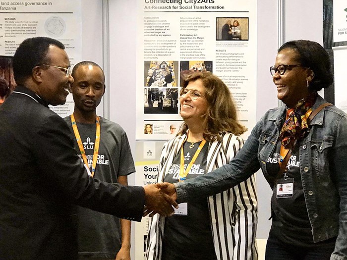 Doktorand skakar hand med representanter från The Ministry of Land, Housing and Human Settlements Development of Tanzania.
