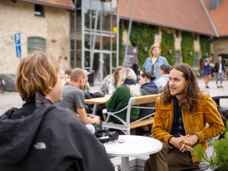Grupp av unga människor framför en byggnad.