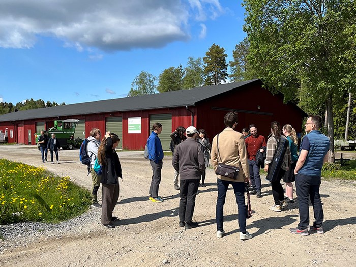 A group of people next to a barn building.
