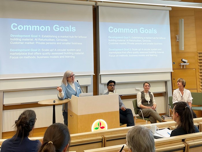 A panel of people at the front of a lecture hall.