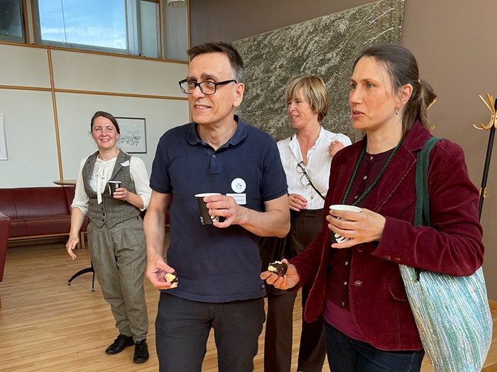 Four people holding coffee cups.