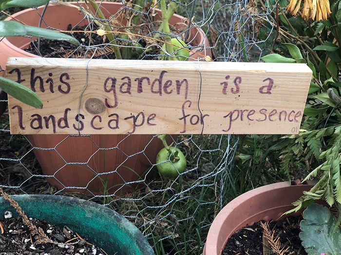 A sign in a park reading This garden is a landscape of presence.