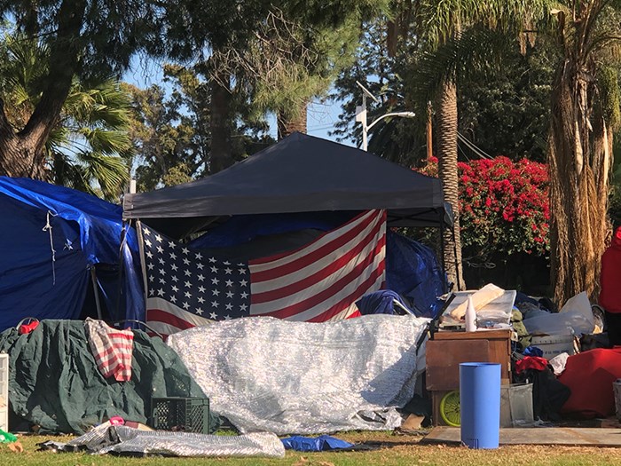 Tent in a park with the American flag.