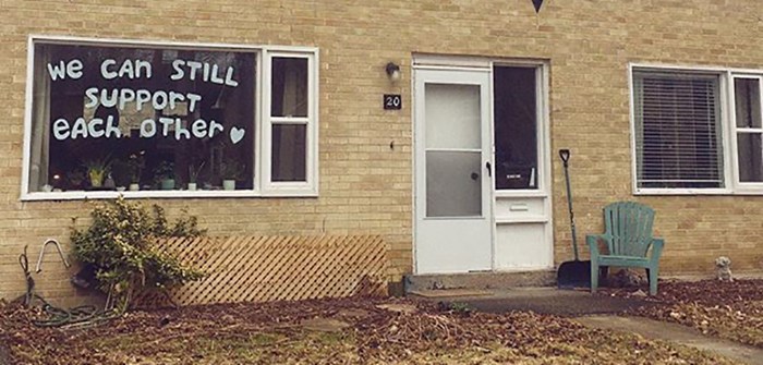 A house during the Covid-19 panedmic with the message in the window about supporting each other.
