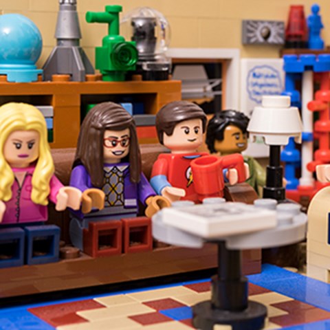 Lego figures sitting around a table.