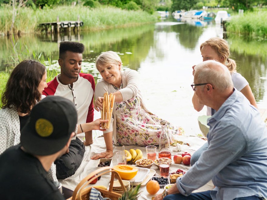 Ett sällskap har picknick vid ån. Foto.