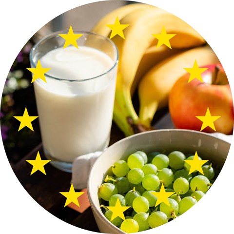 Gröna vindruvor, röda äpplen, bananer och ett glas mjölk.
