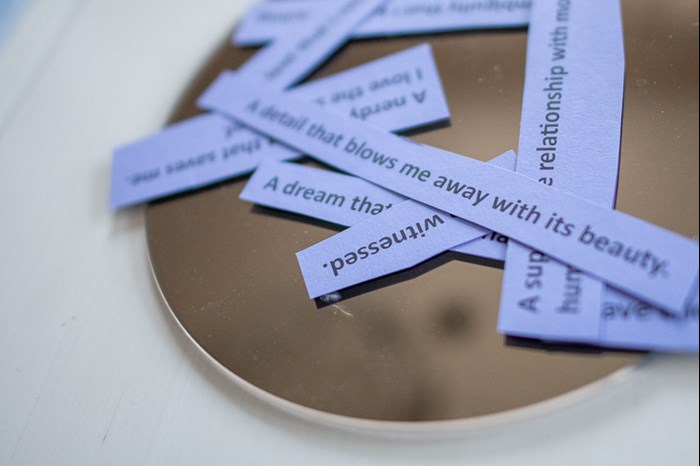 A mirror on a table with purple notes on it. Photo.