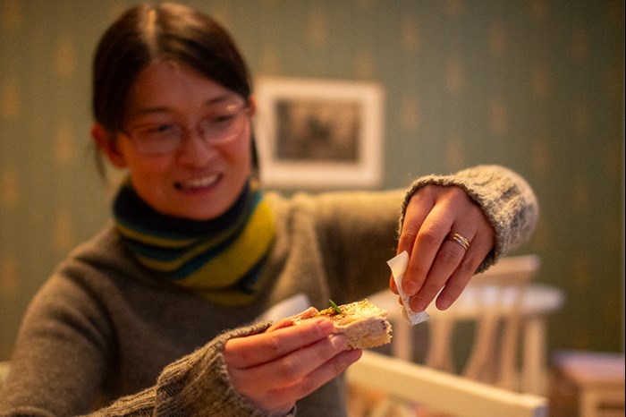 A woman holding a cookie with a note in it. Foto.