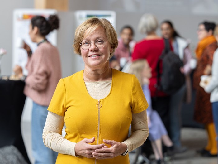 A woman in a yellow shirt among people. Photo.