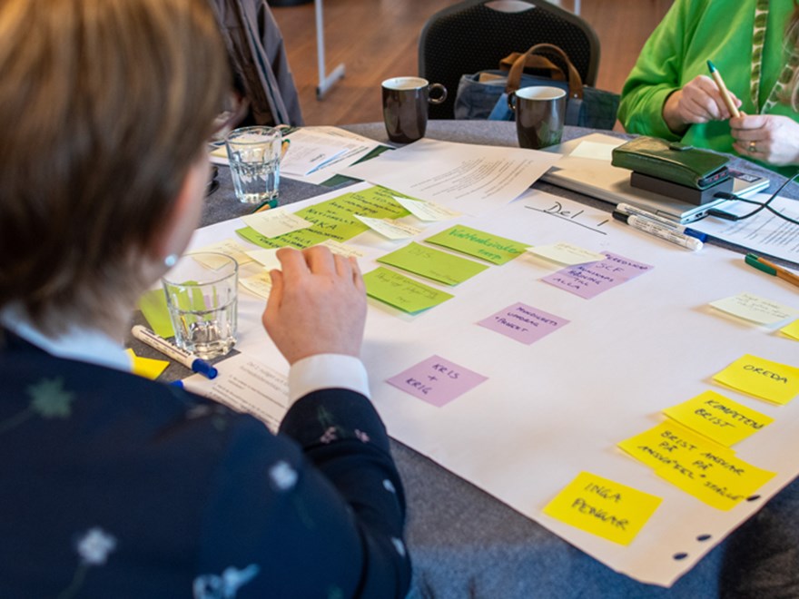 Post-it notes on a white paper on a table. Photo.