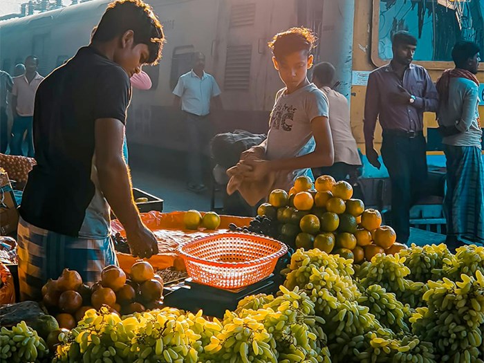 A man selling fruit at a train station. Photo.