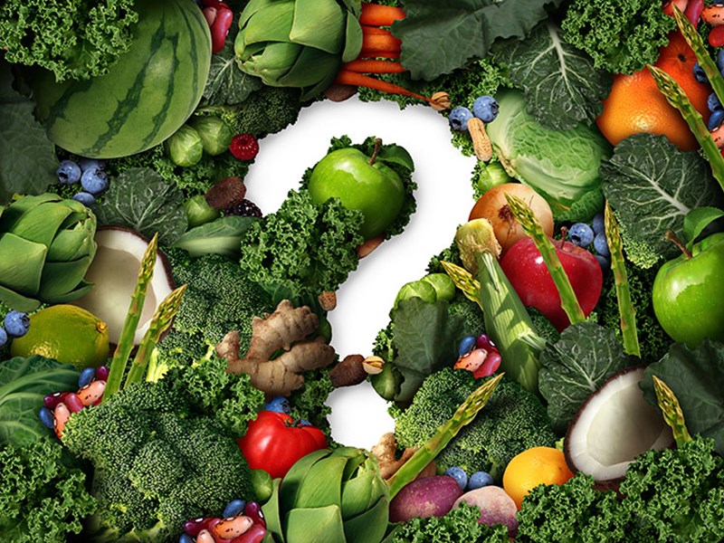 Ett frågetecken omgivet av grönsaker. Foto.