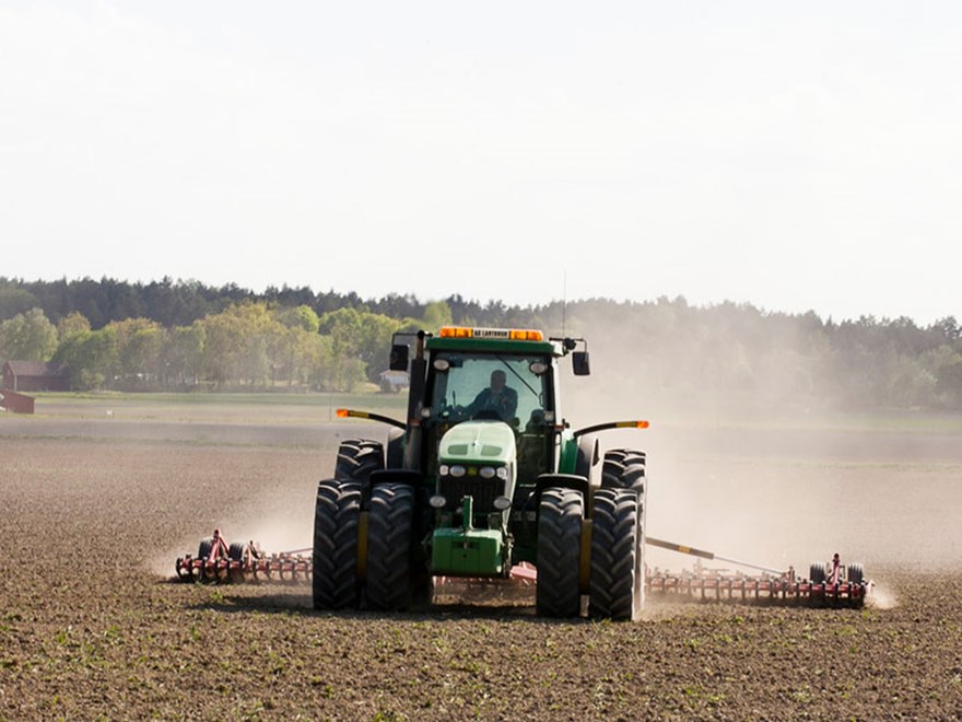 En traktor harvar en åker, foto.