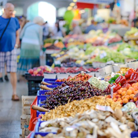 A food market with vegetables and people. Photo. 