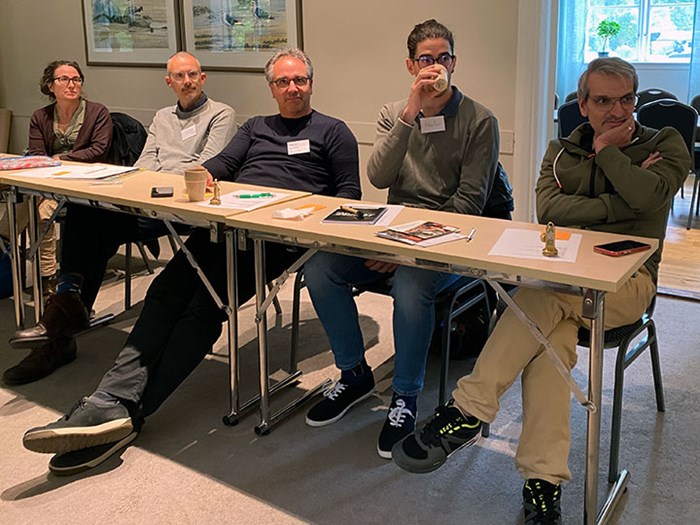 Five course participants sit and listen to a lecture.