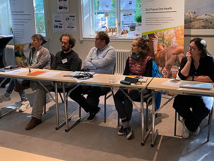 Five course participants sit and listen to a lecture.