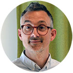 A headshot of a middle-aged man with glasses. Photo.