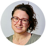 A headshot of a woman with long dark hair and glasses. Photo.