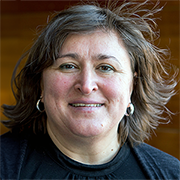 Headshot of a woman with shoulder-length hair and a black jumper. Photo.