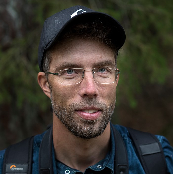 Portrait of a man with a black cap and a backpack. Photo. 