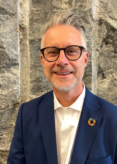 Portrait of smiling man, silver hair, blue jacket