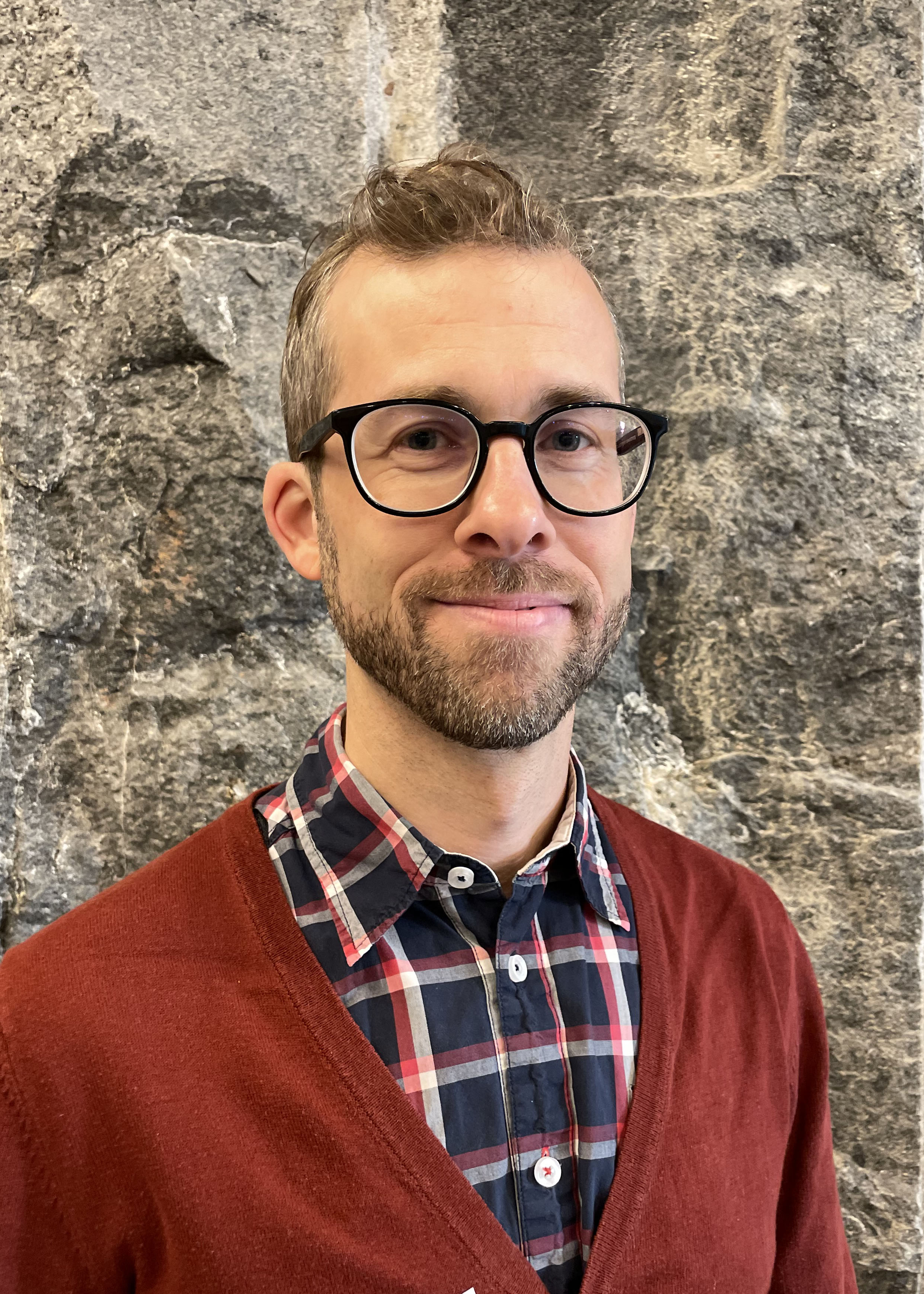 portrait of smiling man, shortbearded, red cardigan