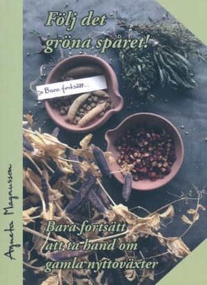 Omslag till boken "Följ det gröna spåret! Bara fortsätt att ta hand om gamla nyttoväxter." På omslaget syns två små keramikskålar fyllda med ärtor. Runt dem ligger torkade örter av olika slag.