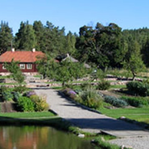 Färgfoto taget i det lokala klonarkivet Kulturreservatet Stabergs bergsmansgård. På fotot ses de olika kvarteren i trädgården.